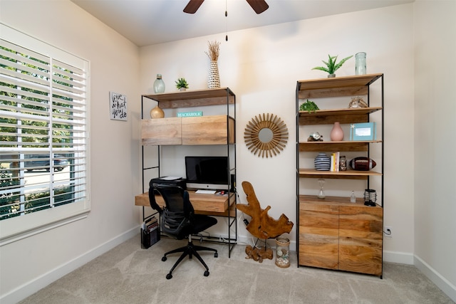 carpeted office space featuring ceiling fan