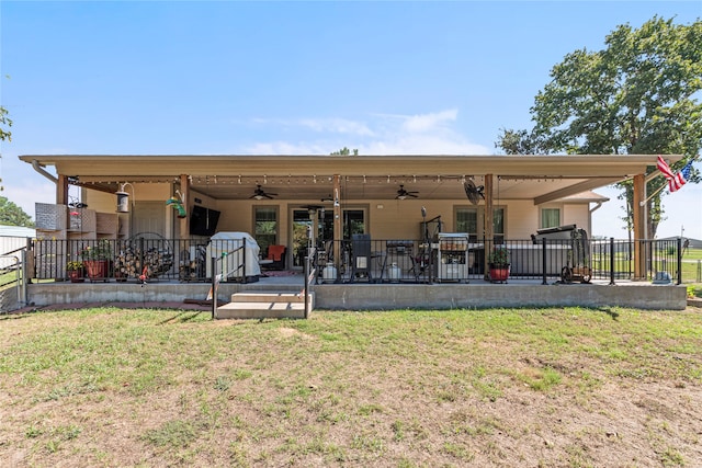 back of property featuring a patio, ceiling fan, and a yard