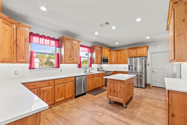 kitchen featuring a kitchen island, stainless steel appliances, ornamental molding, and light hardwood / wood-style flooring