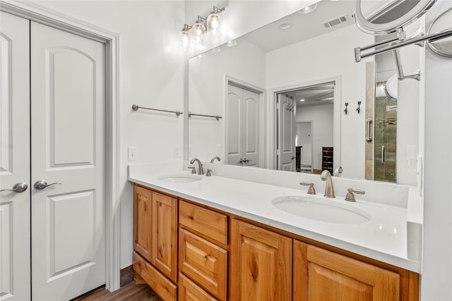 bathroom featuring wood-type flooring, vanity, and an enclosed shower