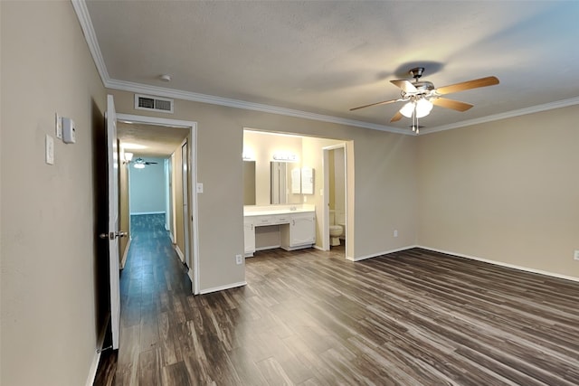 unfurnished bedroom with ensuite bathroom, ornamental molding, a textured ceiling, ceiling fan, and dark hardwood / wood-style floors