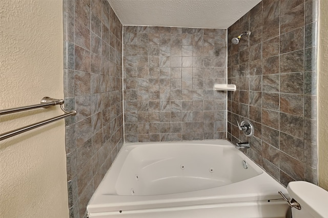 bathroom with tiled shower / bath combo, a textured ceiling, and toilet