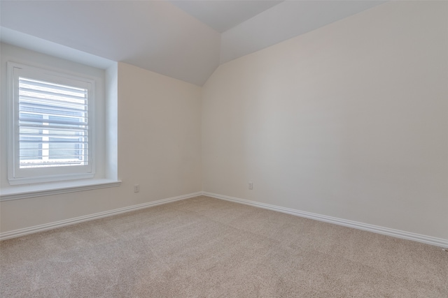 empty room with lofted ceiling and light carpet