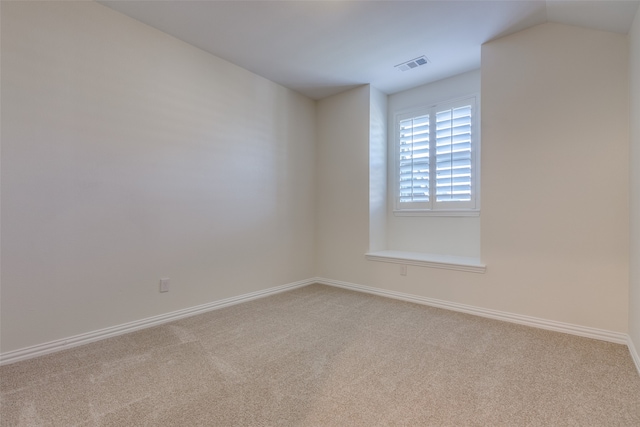 carpeted empty room with lofted ceiling