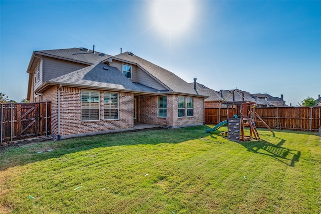 back of property featuring a playground, a patio, and a lawn