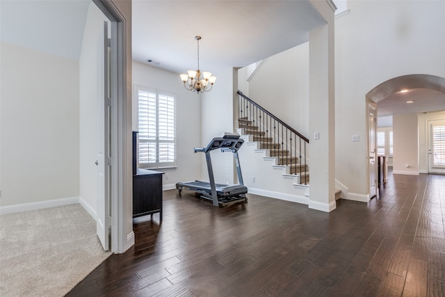 entryway with a notable chandelier and dark wood-type flooring