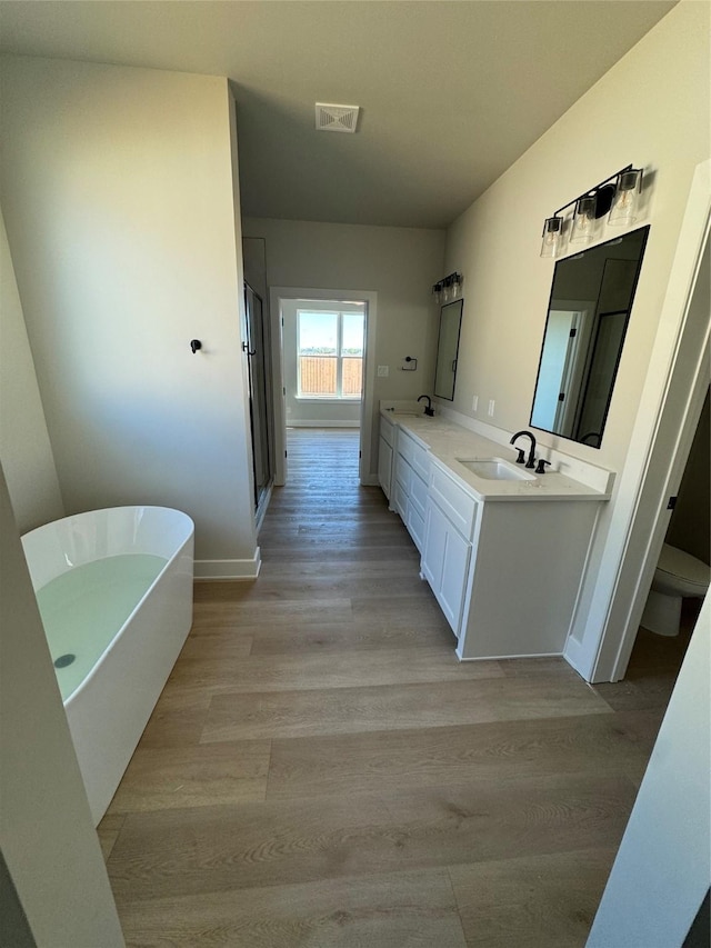 full bathroom featuring hardwood / wood-style floors, vanity, toilet, and separate shower and tub