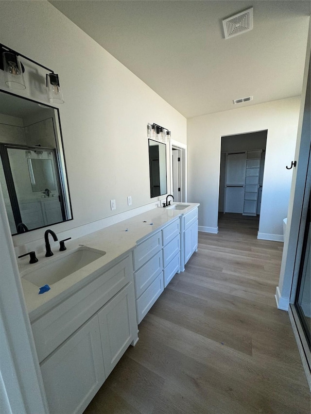 bathroom featuring hardwood / wood-style flooring, vanity, and a shower with door