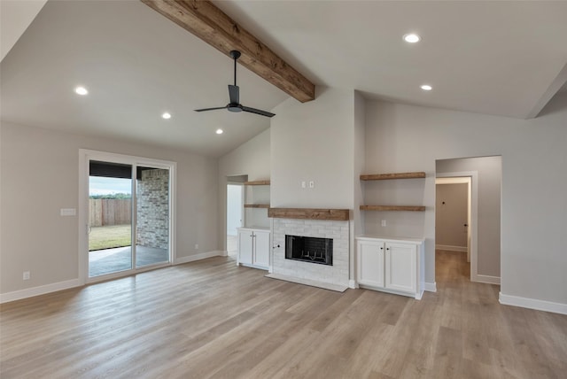 unfurnished living room featuring beamed ceiling, ceiling fan, light hardwood / wood-style floors, and a fireplace