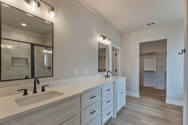 bathroom with vanity, a shower with shower door, and hardwood / wood-style flooring