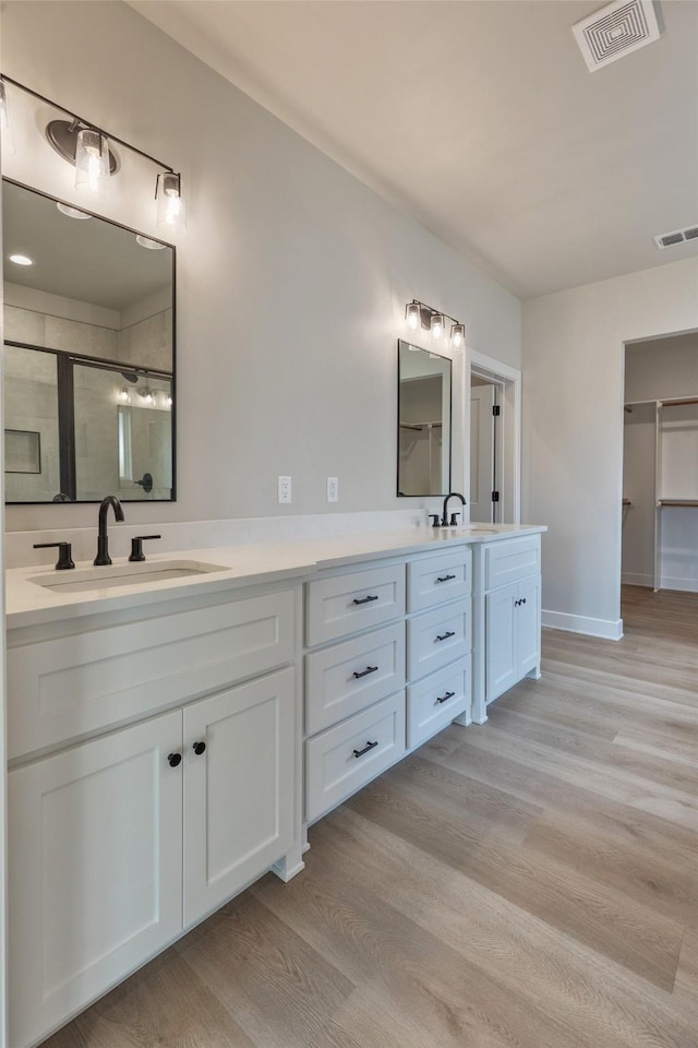 bathroom featuring hardwood / wood-style floors, vanity, and walk in shower