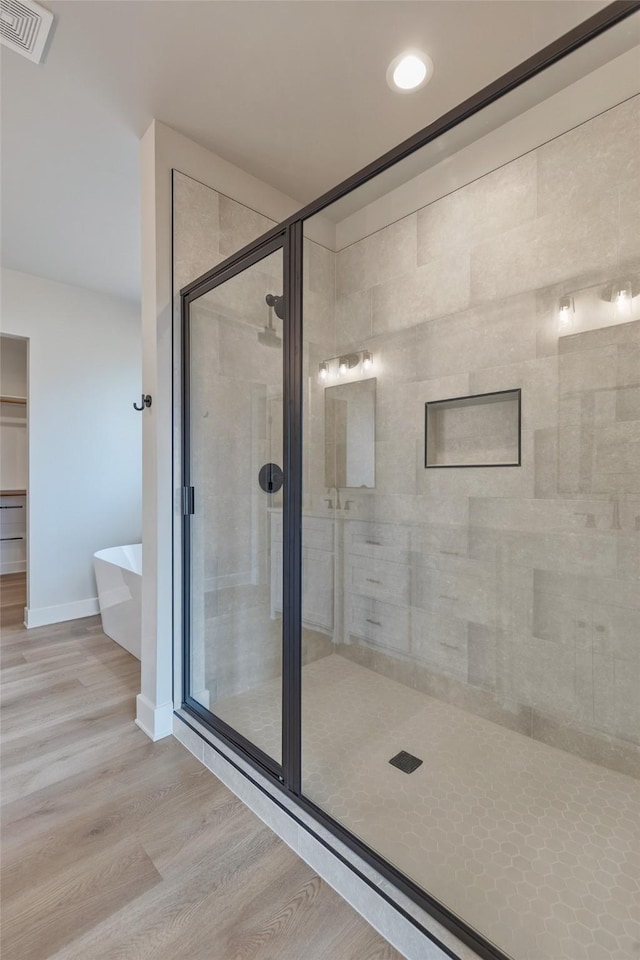 bathroom with hardwood / wood-style floors and separate shower and tub