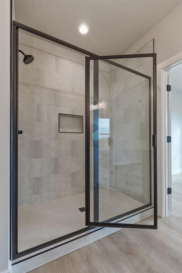 bathroom featuring hardwood / wood-style floors and an enclosed shower