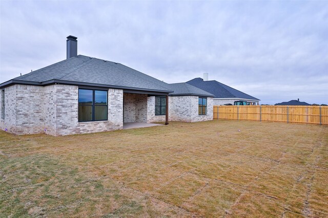 back of house featuring a yard and a patio