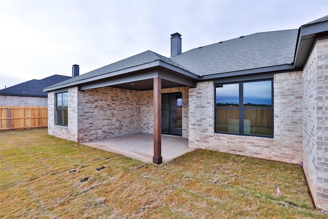 back of property featuring a lawn and a patio