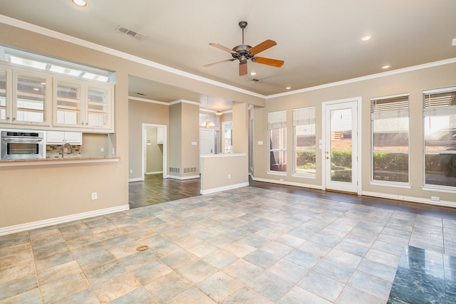 unfurnished living room with ceiling fan with notable chandelier, sink, and ornamental molding