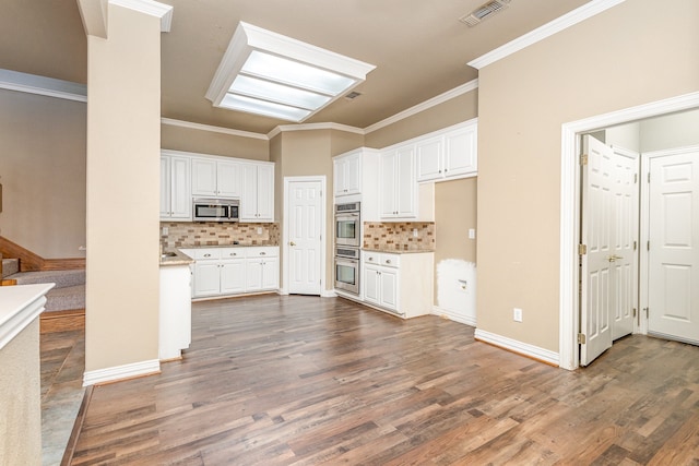 kitchen featuring appliances with stainless steel finishes, backsplash, and white cabinets