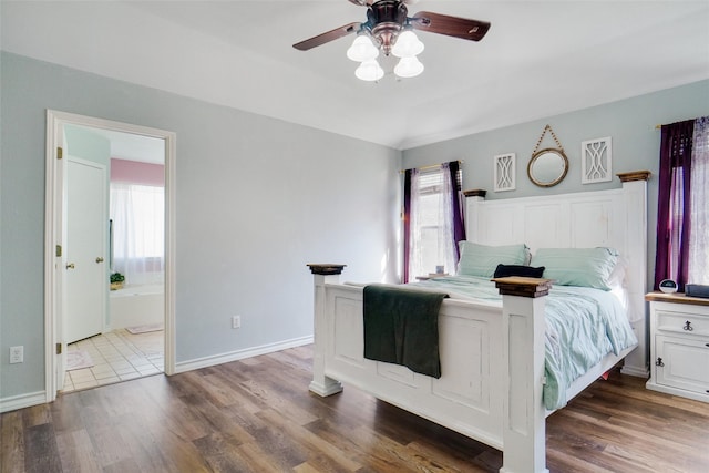 bedroom featuring dark hardwood / wood-style flooring, ceiling fan, and ensuite bath