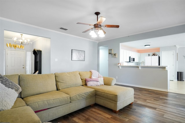 living room featuring sink, ceiling fan with notable chandelier, dark hardwood / wood-style floors, and ornamental molding