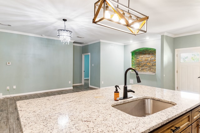 kitchen featuring light stone counters, hanging light fixtures, sink, dark wood-type flooring, and a notable chandelier