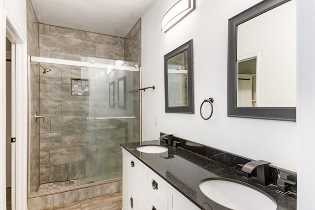 bathroom featuring wood-type flooring, walk in shower, and vanity