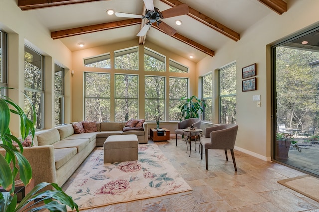 sunroom with ceiling fan, lofted ceiling with beams, and plenty of natural light