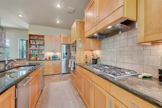 kitchen featuring stainless steel appliances, tasteful backsplash, sink, and dark stone counters