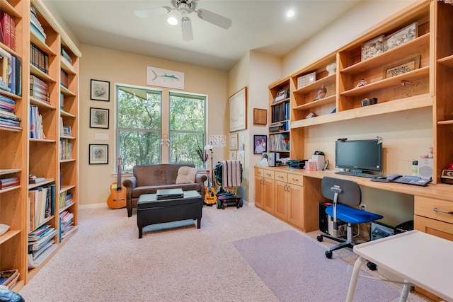 carpeted office featuring built in desk and ceiling fan