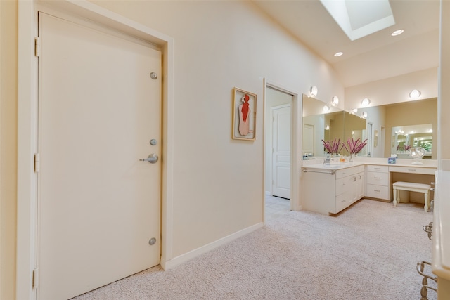 bathroom with vanity and vaulted ceiling with skylight