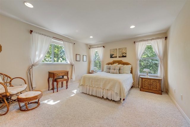 bedroom with multiple windows and light colored carpet