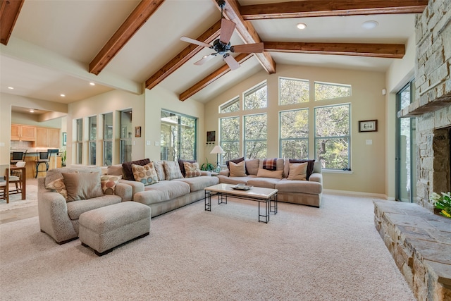 carpeted living room featuring beam ceiling, high vaulted ceiling, a fireplace, and ceiling fan