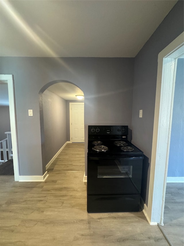 kitchen featuring black range with electric cooktop and light hardwood / wood-style flooring