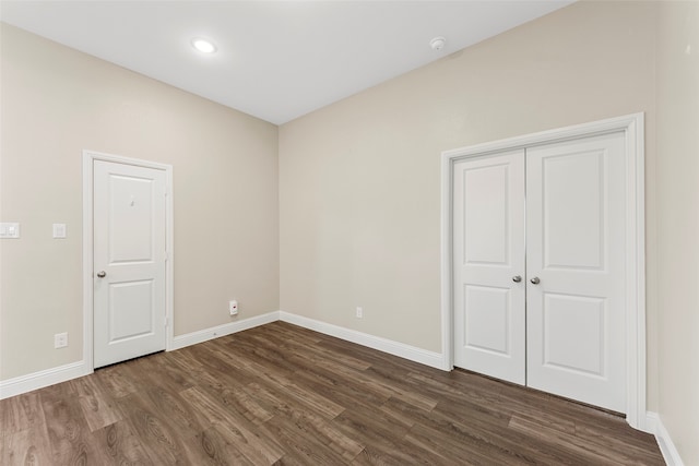 unfurnished bedroom with a closet and dark wood-type flooring