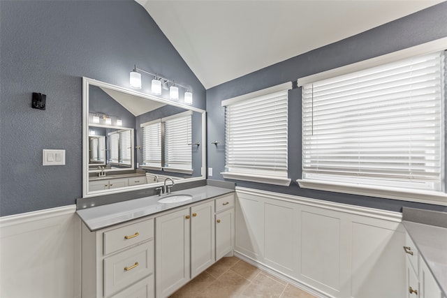 bathroom with vanity, tile patterned flooring, and vaulted ceiling