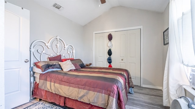 bedroom with vaulted ceiling, wood-type flooring, a closet, and ceiling fan