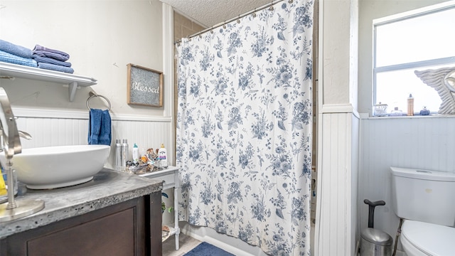 bathroom with toilet, a textured ceiling, a shower with curtain, and vanity