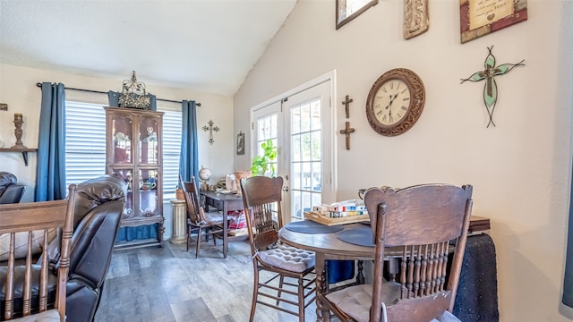 dining area featuring french doors, hardwood / wood-style floors, and lofted ceiling