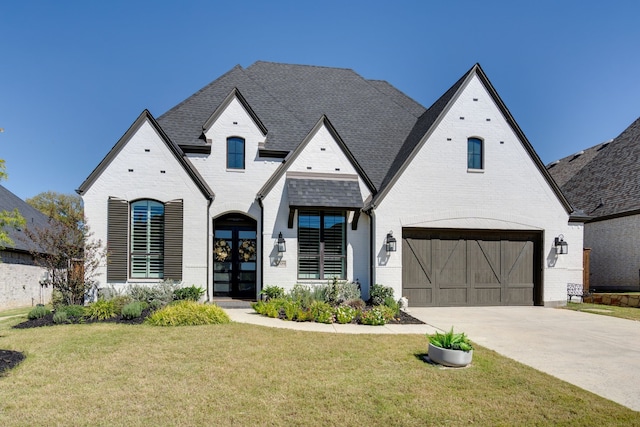 french country inspired facade with a garage and a front yard