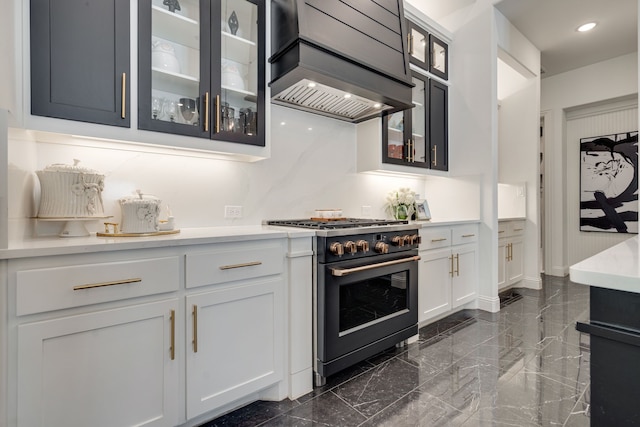 kitchen with premium range hood, high end stainless steel range oven, and white cabinetry