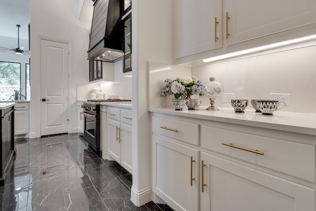 kitchen featuring custom range hood, ceiling fan, high end stainless steel range oven, and white cabinets