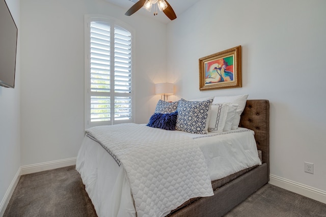 bedroom with dark colored carpet, multiple windows, and ceiling fan