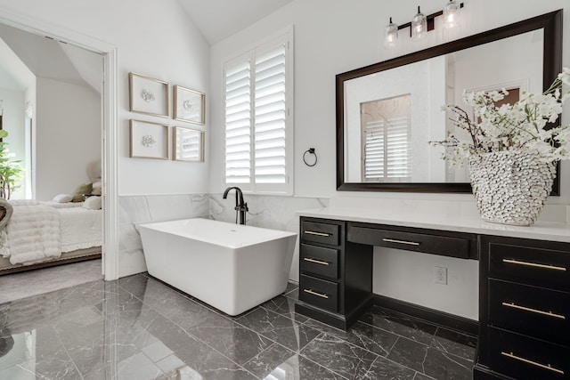 6709 Elderberry Way, Flower Mound, TX 76226 - ensuite bathroom featuring marble tiled floors, vanity, a freestanding bath, wainscoting, and tile walls