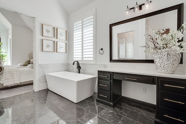 bathroom with vanity, a bathtub, tile walls, and lofted ceiling