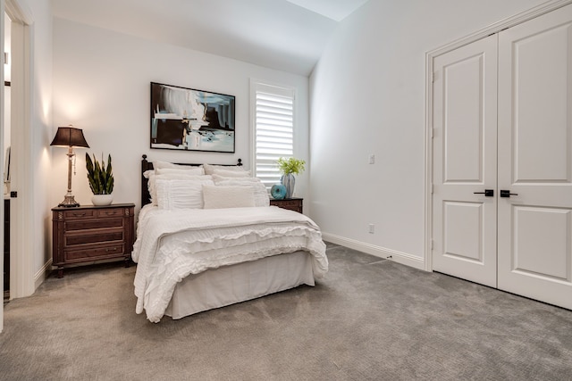 carpeted bedroom featuring a closet and vaulted ceiling