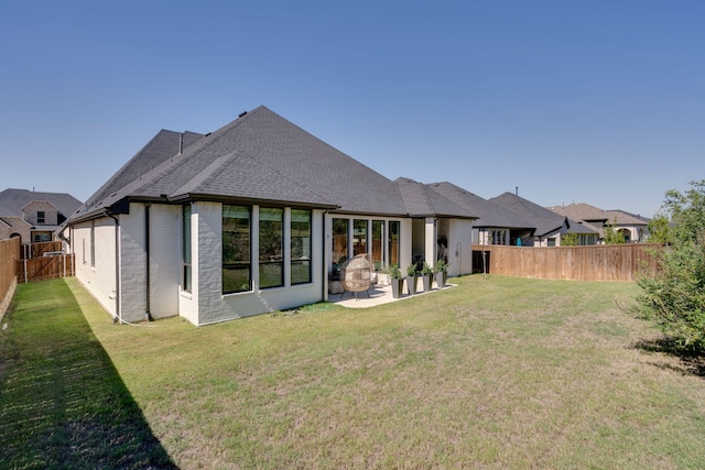 rear view of house featuring a yard and a patio