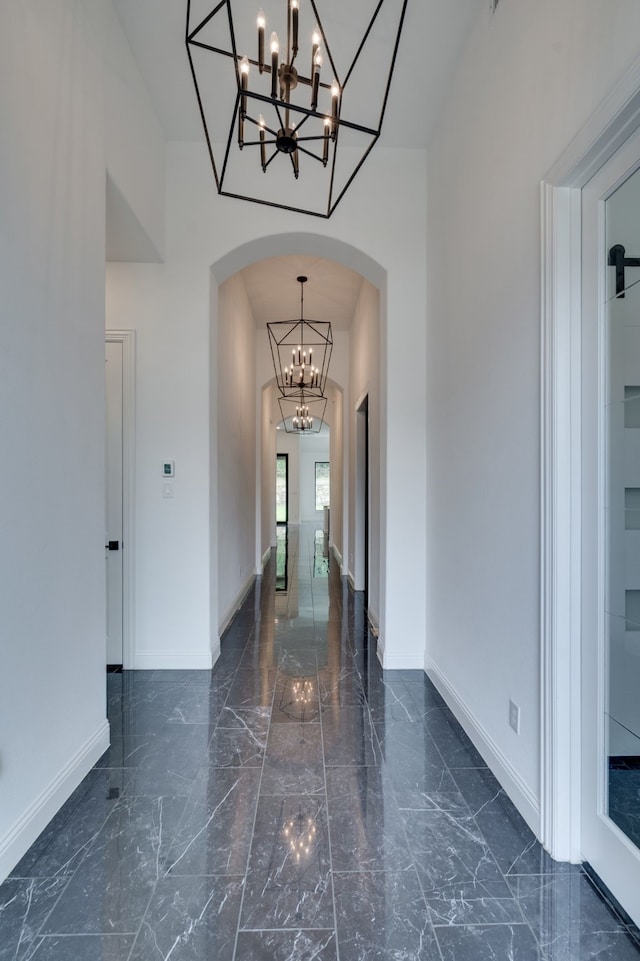 6709 Elderberry Way, Flower Mound, TX 76226 - corridor with a chandelier, arched walkways, marble tiled floors, and a towering ceiling