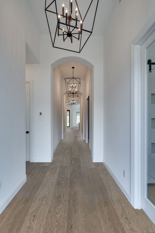 6709 Elderberry Way, Flower Mound, TX 76226 - hallway with a chandelier, wood finished floors, and arched walkways