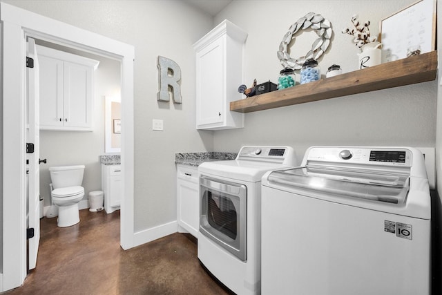 laundry room featuring separate washer and dryer and cabinets