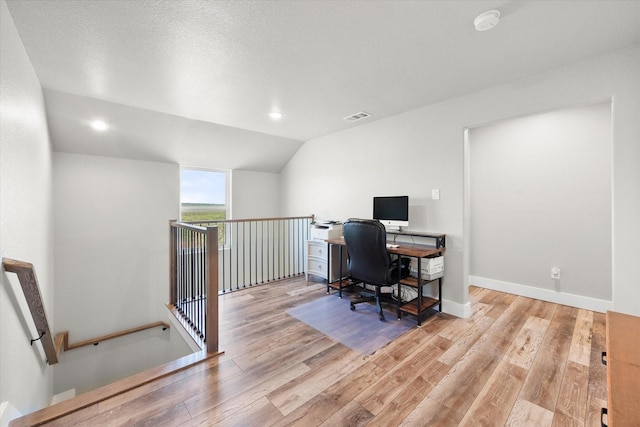 office space featuring lofted ceiling and light hardwood / wood-style floors