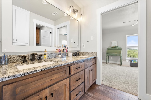 bathroom featuring ceiling fan, vanity, and wood-type flooring